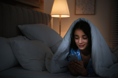 woman in bed on her phone